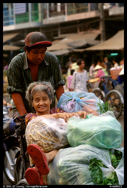 Elderly woman back from the market with plenty of groceries makes good use of cyclo. Ho Chi Minh City, Vietnam