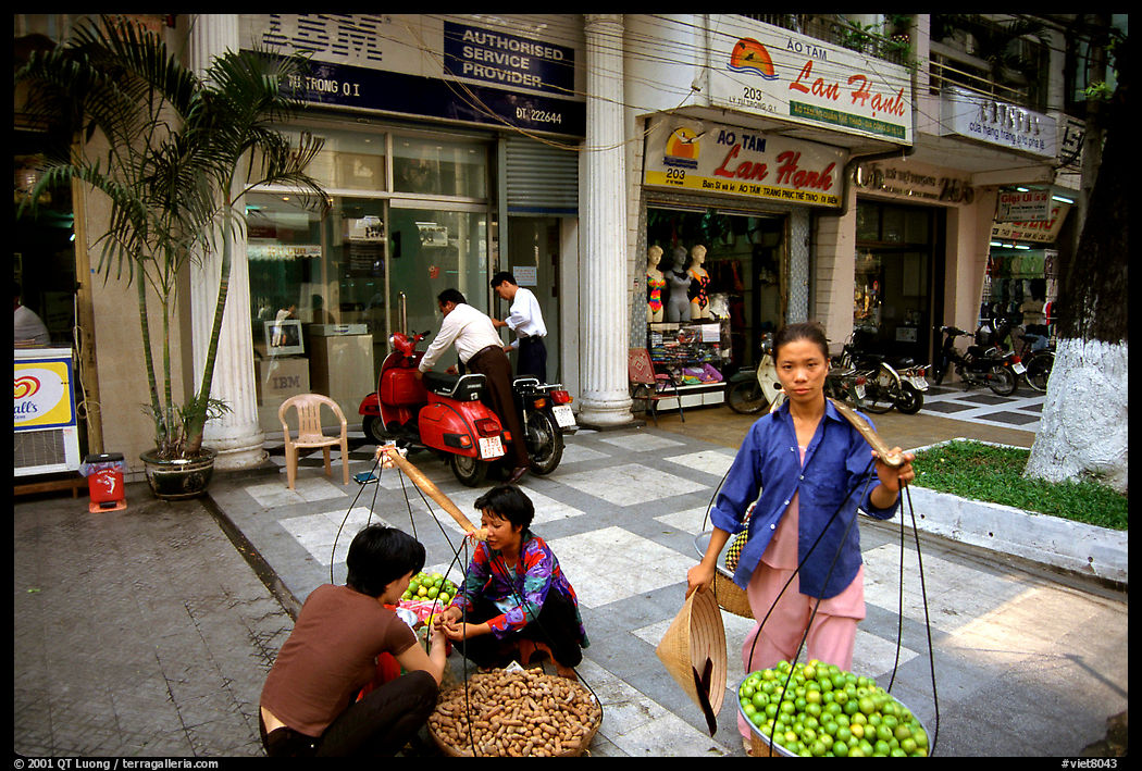 Old and new: street fruit vendors and computer store. Ho Chi Minh City, Vietnam