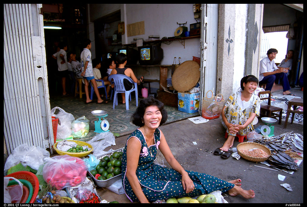 Old and new: street vendors and kids playing in a video games store. Ho Chi Minh City, Vietnam