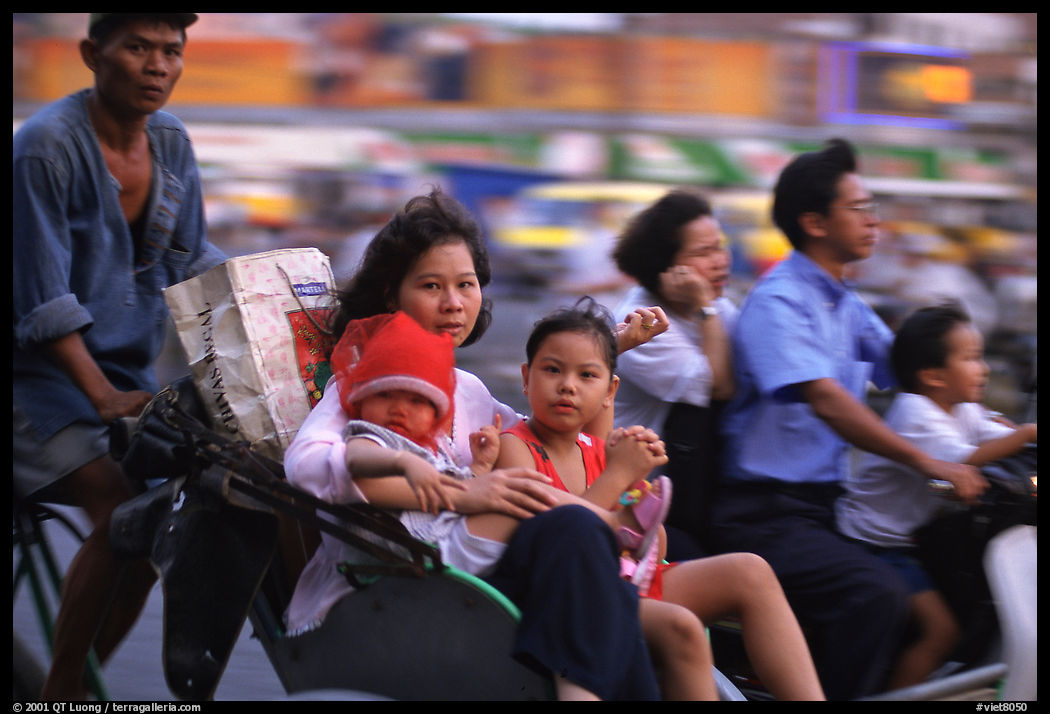 Wheels are seldom for single drivers: families on cyclo and motorbike. Ho Chi Minh City, Vietnam