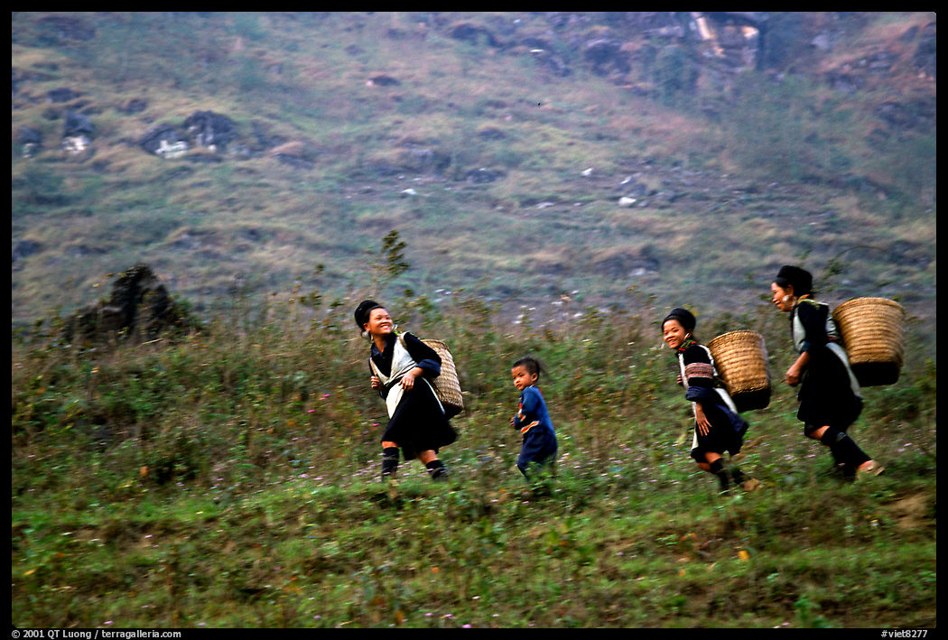 Hmong women back from the fields. The back basket is typically used by mountain tribes. Sapa, Vietnam