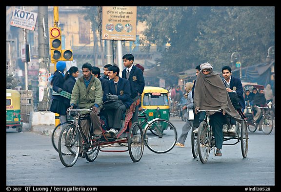 Cycle-rickshaws carrying uniformed schoolchildren. New Delhi, India