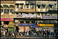 Street with many people waiting in front of closed stores, Old Delhi. New Delhi, India