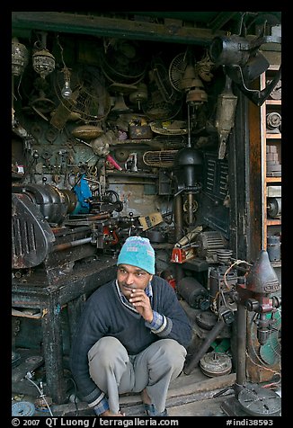 Man sitting in front of machine parts shop, Old Delhi. New Delhi, India (color)