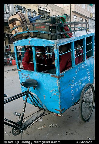 Schoolchildren in an enclosed  box towed by cycle. New Delhi, India (color)