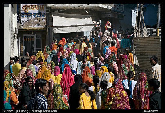 Street with women in colorful sari following wedding procession. Jodhpur, Rajasthan, India (color)