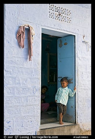Young boy in doorway of house painted light blue. Jodhpur, Rajasthan, India