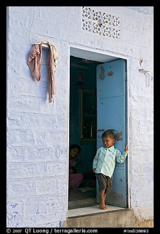 Young boy in doorway of house painted light blue. Jodhpur, Rajasthan, India (color)