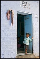 Young boy in doorway of house painted light blue. Jodhpur, Rajasthan, India