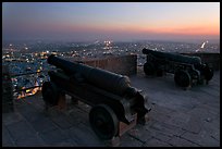 Cannons on top of Mehrangarh Fort, and city lights and dusk. Jodhpur, Rajasthan, India ( color)