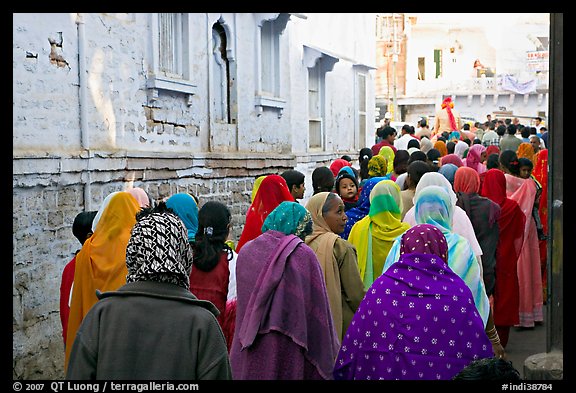 Women in colorful sari walking a  narrow street during wedding. Jodhpur, Rajasthan, India
