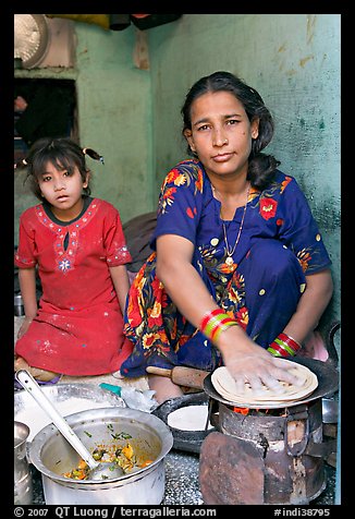 Woman and girl preparing chapati bread. Jodhpur, Rajasthan, India (color)