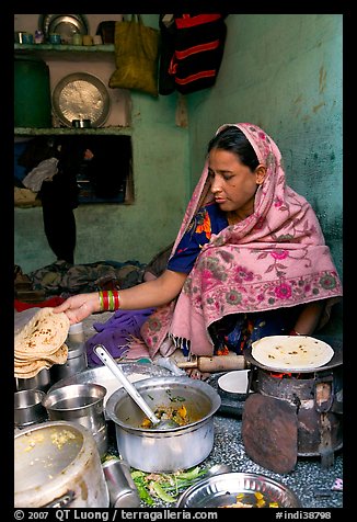 Woman with headscarf stacking chapati bread. Jodhpur, Rajasthan, India (color)