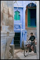 Boy riding a bicycle in a narrow old town street. Jodhpur, Rajasthan, India (color)