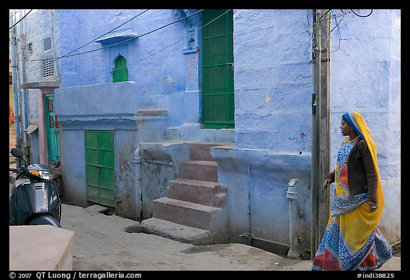 Woman walking in narrow street with blue walls. Jodhpur, Rajasthan, India