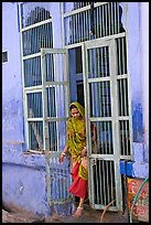 Woman stepping out of door. Jodhpur, Rajasthan, India