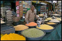 Man in front of grain and spice store, Sardar market. Jodhpur, Rajasthan, India