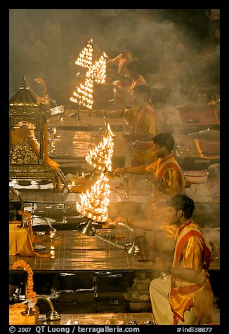 Holy men lifting chandeliers during evening puja. Varanasi, Uttar Pradesh, India