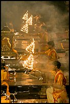 Holy men lifting chandeliers during evening puja. Varanasi, Uttar Pradesh, India (color)