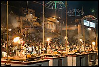 Pujari (priests) performing arti ceremony in front of large attendance. Varanasi, Uttar Pradesh, India (color)
