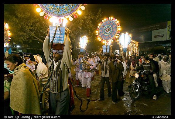 Men carrying bright electric signs during wedding procession. Varanasi, Uttar Pradesh, India (color)