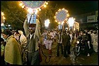 Men carrying bright electric signs during wedding procession. Varanasi, Uttar Pradesh, India