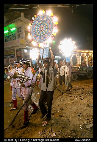 Uniformed musicians and men carrying lights during wedding procession. Varanasi, Uttar Pradesh, India (color)