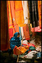 Woman selling fabrics at night. Varanasi, Uttar Pradesh, India