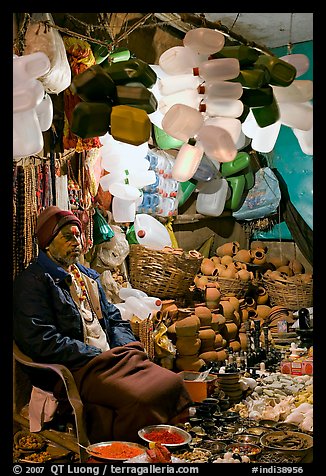 Man selling water jugs and other supplies for pilgrims near the Ganges River. Varanasi, Uttar Pradesh, India