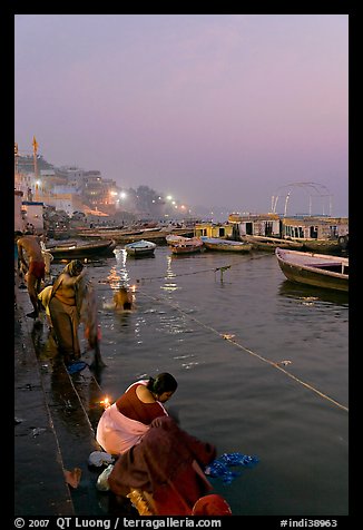 Women soaking clothes in the Ganges River at dawn. Varanasi, Uttar Pradesh, India (color)