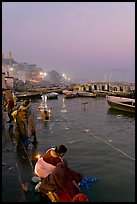 Women soaking clothes in the Ganges River at dawn. Varanasi, Uttar Pradesh, India (color)