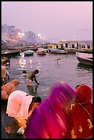 Women on the banks of the Ganga River in rosy dawn light. Varanasi, Uttar Pradesh, India