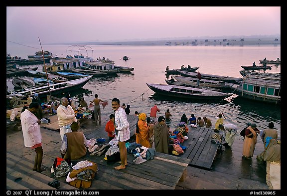 Men preparing for ritual bath on banks of Ganges River at dawn. Varanasi, Uttar Pradesh, India