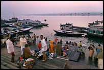 Men preparing for ritual bath on banks of Ganges River at dawn. Varanasi, Uttar Pradesh, India