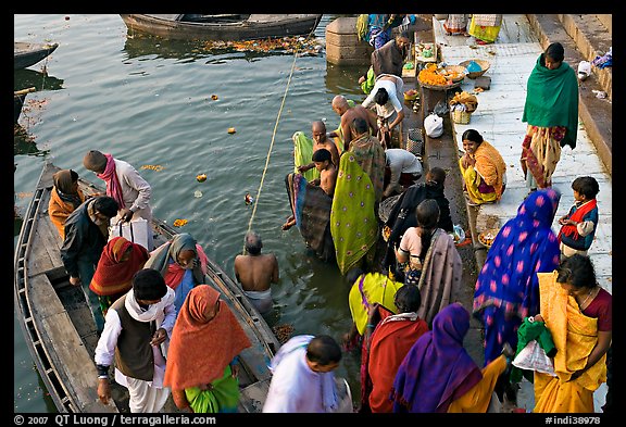 Hindu pilgrims walk out of boat onto Dasaswamedh Ghat. Varanasi, Uttar Pradesh, India (color)