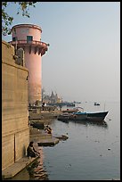 Man sitting on edge of Ganges River. Varanasi, Uttar Pradesh, India