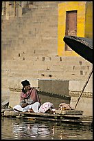 Man sitting near unbrella. Varanasi, Uttar Pradesh, India