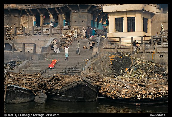 Steps of Manikarnika Ghat with body swathed in cloth and firewood piles. Varanasi, Uttar Pradesh, India