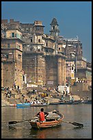 Man rowing boat beneath Munshi Ghat. Varanasi, Uttar Pradesh, India