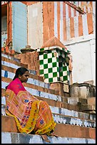 Woman sitting on temple steps. Varanasi, Uttar Pradesh, India