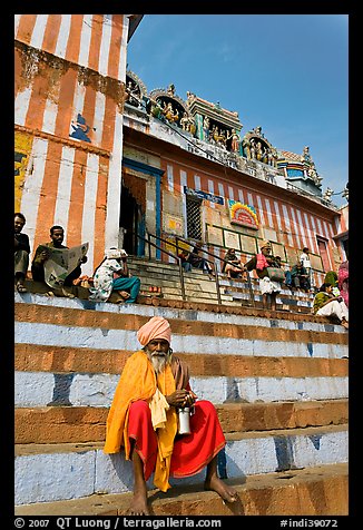 Holy man sitting on temple steps, Kedar Ghat. Varanasi, Uttar Pradesh, India