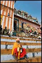 Holy man sitting on temple steps, Kedar Ghat. Varanasi, Uttar Pradesh, India (color)