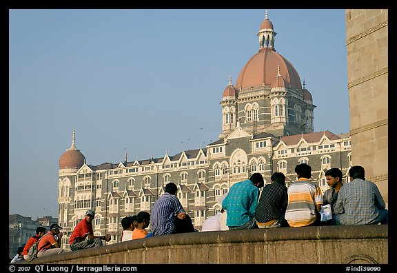 Men sitting in front of Taj Mahal Palace Hotel. Mumbai, Maharashtra, India (color)