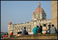 Men sitting in front of Taj Mahal Palace Hotel. Mumbai, Maharashtra, India