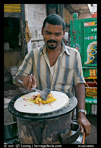 Man preparing breakfast dosa, Colaba Market. Mumbai, Maharashtra, India (color)