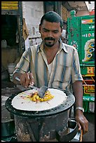 Man preparing breakfast dosa, Colaba Market. Mumbai, Maharashtra, India (color)