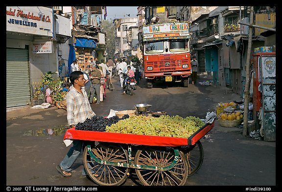 Vegetable vendor pushing cart with truck in background, Colaba Market. Mumbai, Maharashtra, India (color)