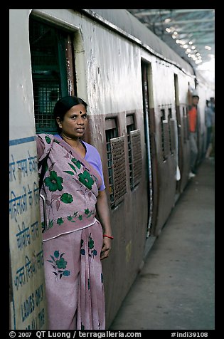 Woman standing at door of suburban train. Mumbai, Maharashtra, India (color)