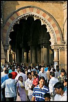 Crowd pass beneath an archway, Chhatrapati Shivaji Terminus. Mumbai, Maharashtra, India (color)