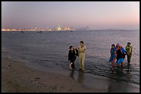 Women walking in water by night, Chowpatty Beach. Mumbai, Maharashtra, India ( color)